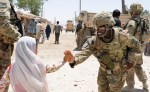 Staff Sgt. Samira Abdullahmuhammad with a female engagement team, 40th Engineer Battalion, 170th Infantry Brigade Combat Team, gives a high-five to a child during a mission to deliver medical supplies to a clinic in Deh Dadi, Afghanistan, June 1.